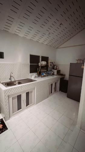a kitchen with a sink and a refrigerator at Kood Life in Ko Kood