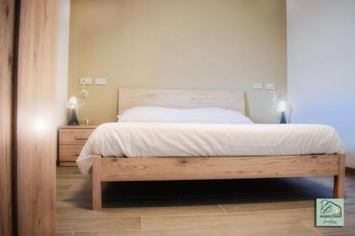 a bedroom with a large bed with a wooden frame at Residenza Borgo in Manerbio