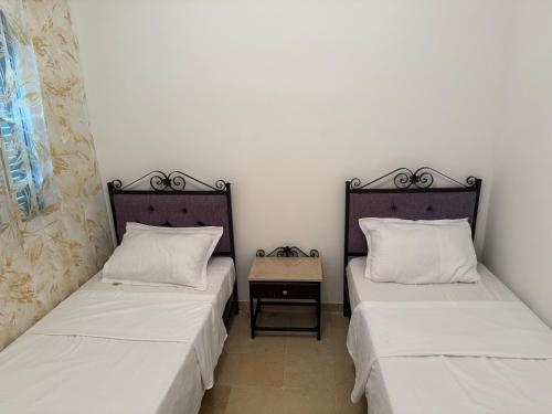 two beds sitting next to each other in a room at F3 et Piscine Port Yasmine Hammamet in Yasmine
