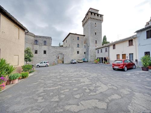 a large castle with cars parked in a parking lot at Mansion in Prodo near Lake Bolsena in Prodo