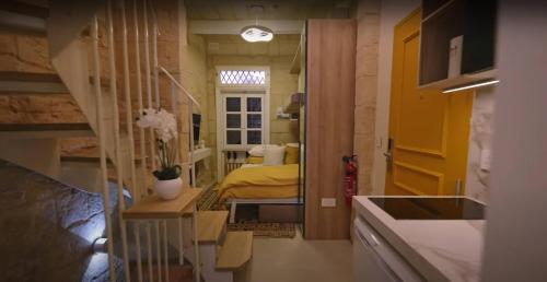 a small room with a bedroom with a bed at Sand - Rooftop Views, Wine Cellar & Espresso in Senglea