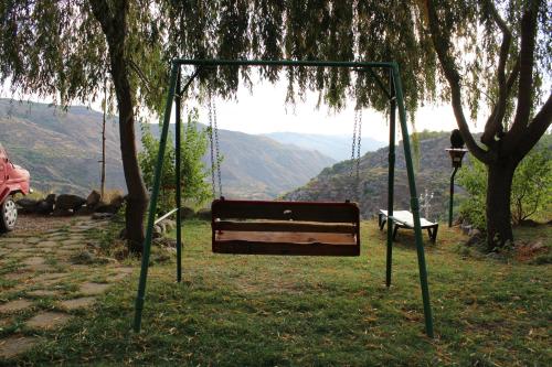 a swing hanging from a tree with a view at GeghardCamping in Goghtʼ