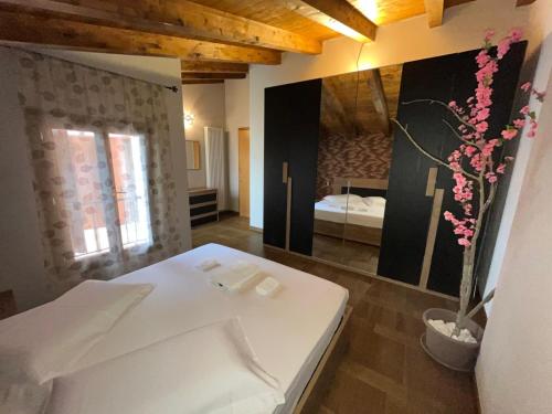 a bedroom with a white bed and a room with a bed sqor at Suite Deluxe Appartaments Black in Fabbrico