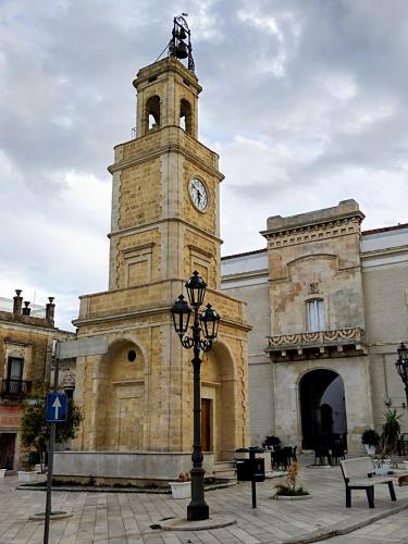 a building with a clock tower in front of a building at Casabella in Ginosa