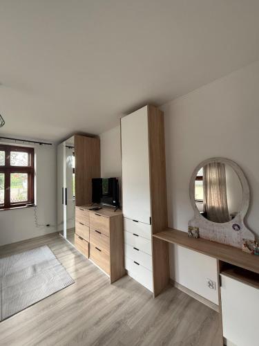 a room with a mirror and a dresser and a television at Parkowa Apartment in Wadowice