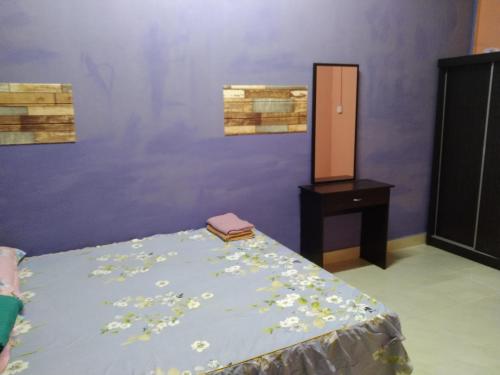a bedroom with a bed with flowers on it at Putat Gajah Villa PASIR MAS in Pasir Mas