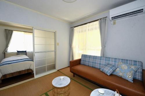 una sala de estar con un sofá y una cama en StayChacha 城下町茶茶1F2F 一棟貸切, en Marugame