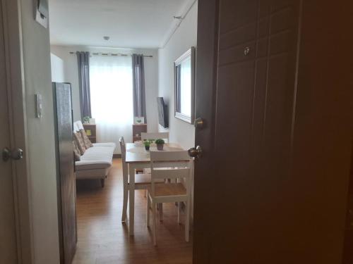 a living room with a table and a dining room at The Dwelling Place at Metrotowne Las Pinas in Manila