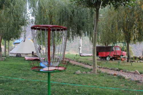 a frisbee golf basket in a field with a tent at GeghardCamping in Goghtʼ