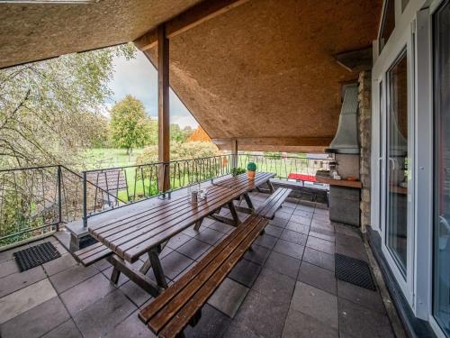 a porch with a wooden bench on a balcony at Spa Cottage in Fagnes in Waimes