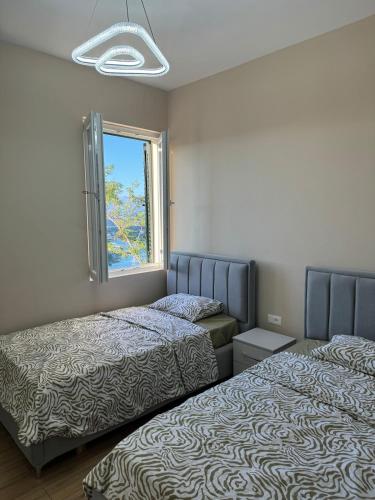 a bedroom with two beds and a window at The Lake Villa in Tirana