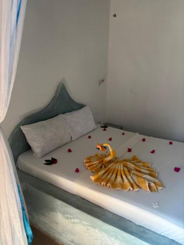 a bed with hearts and a stuffedanimal on it at Stonefish Inn Jambiani in Jambiani