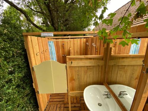 a wooden bathroom with a sink and a tree at Oasis Graine de Joie in Cabrerets