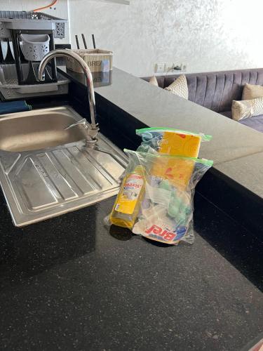a kitchen counter with a sink and two bags of food at Mehdia's Paradise in Kenitra