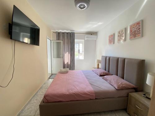 une chambre avec un lit et une télévision à écran plat dans l'établissement Thanas Apartment, à Himarë