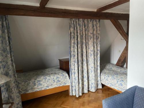 a bedroom with two beds and a curtain at Altes Forstamt in Wennigsen