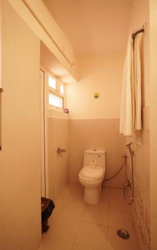 a bathroom with a toilet and a window at The Harmony Circle - Jaipur in Jaipur