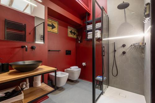 a bathroom with red walls and a glass shower at La Dolce Suite Porta Romana Metro in Milan