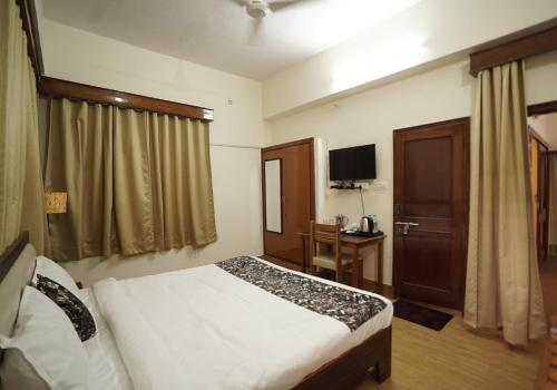 a hotel room with a bed and a television at The Harmony Circle - Jaipur in Jaipur