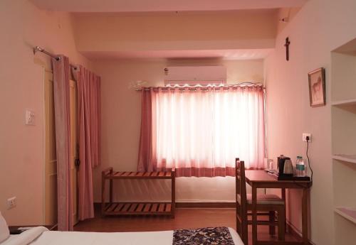 a bedroom with a bed and a window with a table at The Harmony Circle - Jaipur in Jaipur