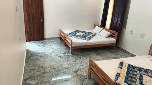 a living room with two beds and a couch at Swagat hotel in Uttarkāshi