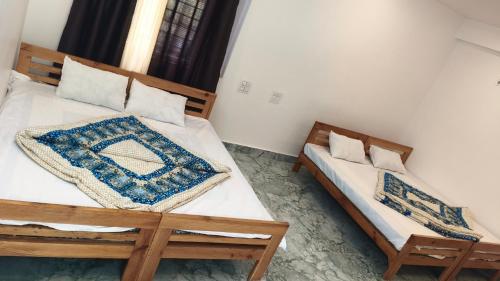 two twin beds in a room withthritisthritisthritisthritisthritisthritisthritisthritisthritis at Swagat hotel in Uttarkāshi
