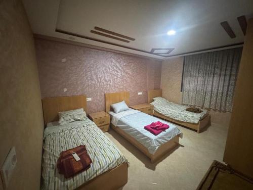 une chambre avec deux lits et deux sacs dessus dans l'établissement Wassime location, à Taourirt