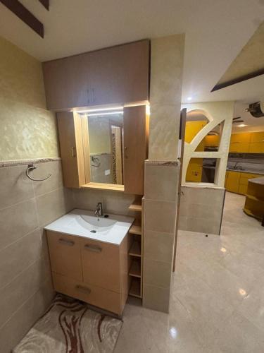 a small bathroom with a sink and a mirror at Wassime location in Taourirt