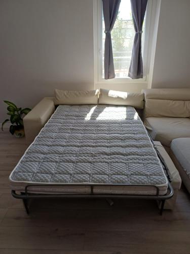 a bed sitting in a room with a window at Garden House in Sanremo