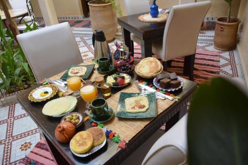 een tafel met ontbijtproducten en drankjes erop bij Riad Dar Tuscia in Marrakesh