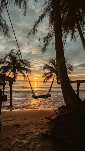 a hammock on a beach with palm trees and the ocean at Kood Life in Ko Kood
