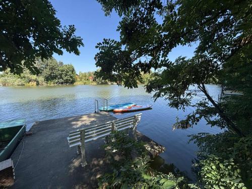 a bench and a boat on a lake at Peresi paradicsom in Mezőtúr