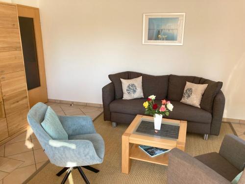 a living room with a couch and two chairs and a table at Dünenhaus in Göhren