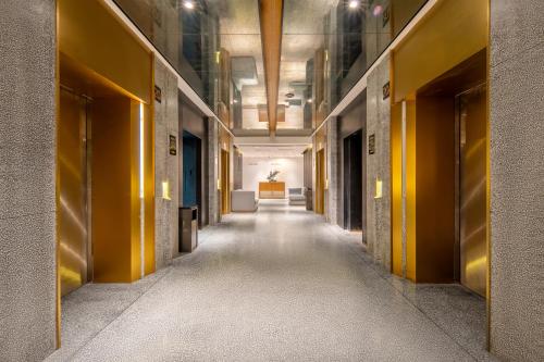 an empty hallway in a building with yellow walls at Chongqing From Hotel in Chongqing
