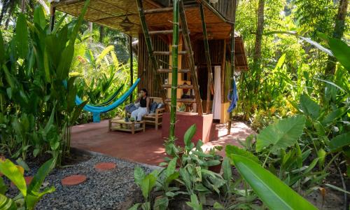 a person sitting in a chair in a swing at Water to Forest Ecolodge in Loboc