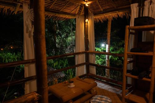 a room with a bed and a table and a window at Water to Forest Ecolodge in Loboc