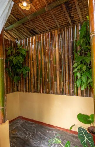 a room with a bamboo wall with plants at Water to Forest Ecolodge in Loboc