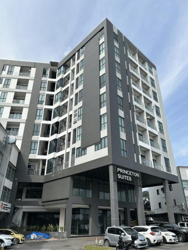 a large building with cars parked in a parking lot at Princeton Suites 3BR 2BH Apartment Near Airport in Kuching