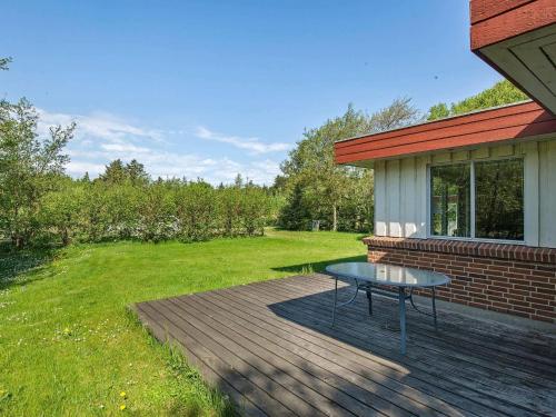 a table sitting on a deck next to a house at 8 person holiday home in Hurup Thy-By Traum in Sindrup