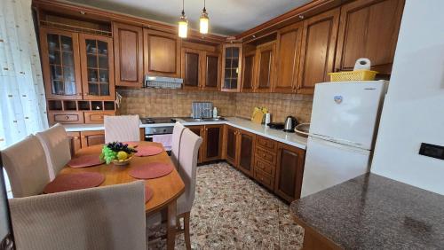 a kitchen with a table and a white refrigerator at Eni's Villa, 5km From Shengjini Beach in Lezhë