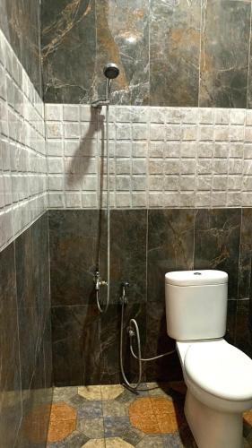 a bathroom with a shower with a toilet in it at Riltree hotel in Bulukumba