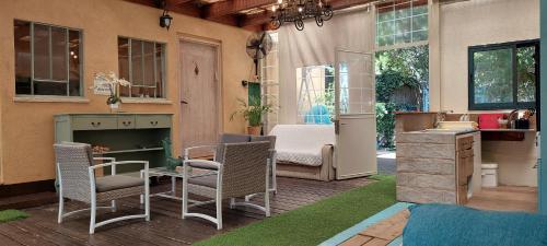 a patio with chairs and a table and a desk at Love & Lemons in Yesod Hamaala