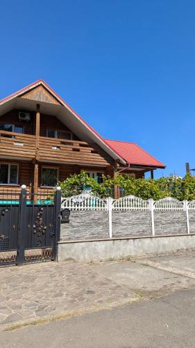 a wooden house with a fence in front of it at Заміський будинок кімната студія Pet - friendly in Mukacheve