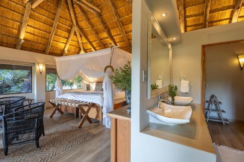 a bathroom with a sink and a bed in a room at Karongwe - River Safari Lodge in Hoedspruit