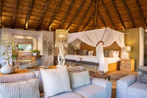 a bedroom with a bed and a living room at Karongwe - River Safari Lodge in Hoedspruit