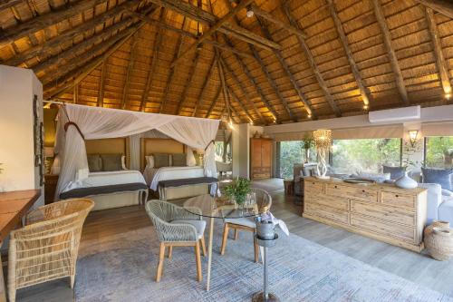 a living room with a bed and a table and chairs at Karongwe - River Safari Lodge in Hoedspruit