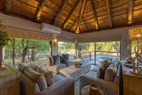 a large living room with couches and a pool at Karongwe - River Safari Lodge in Hoedspruit