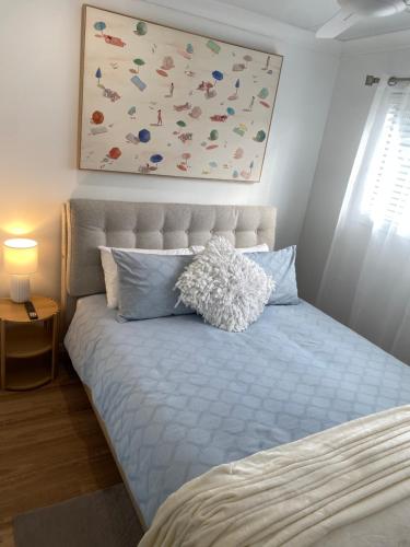 a bedroom with a bed with a painting above it at The Lazy Roo accommodation in Moonee Beach