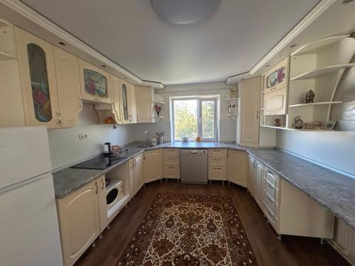 una grande cucina con mobili bianchi e una finestra di Girasole a Chişinău