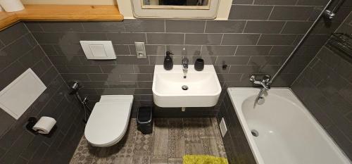 a bathroom with a sink and a toilet and a bath tub at Al Pacino Family Lux Apartment in Rīga